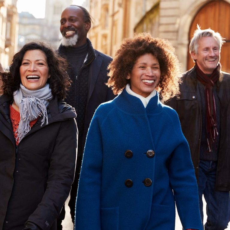 Individuelle Erlebnisse Eine Gruppe von 2 Frauen und 2 Männern geht lächelnd durch die Altstadt.