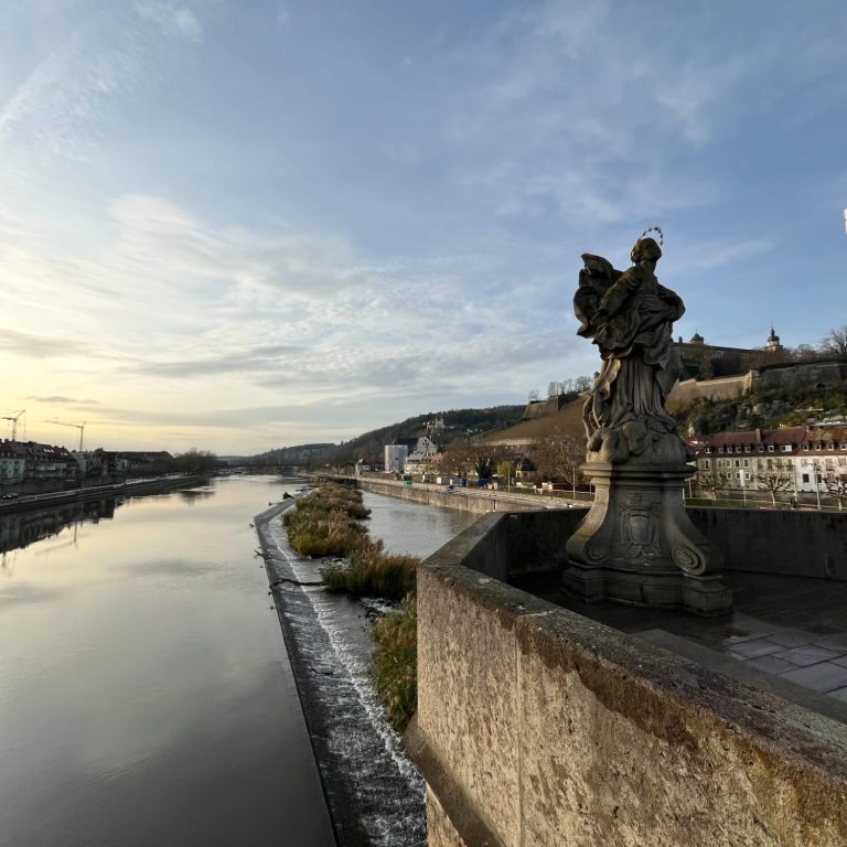 Main Blick von der Alten Mainrücke auf Main, Festung Marienberg. Im Fokus ist eine Figur, die Patronia Franconiae, auf der Alten Mainbrücke.